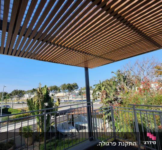 פרגולה מעץ מעל מרפסת עם צמחייה מסביב